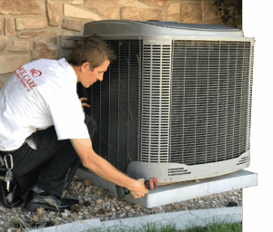 A technician in a white shirt with a We Care logo is installing an outdoor AC unit.