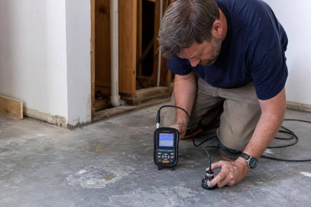 Technician inspecting a suspected leak beneath a concrete slab in San Marcos